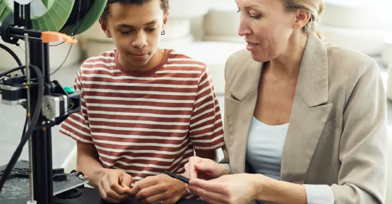 Woman and teen with 3D printer.
