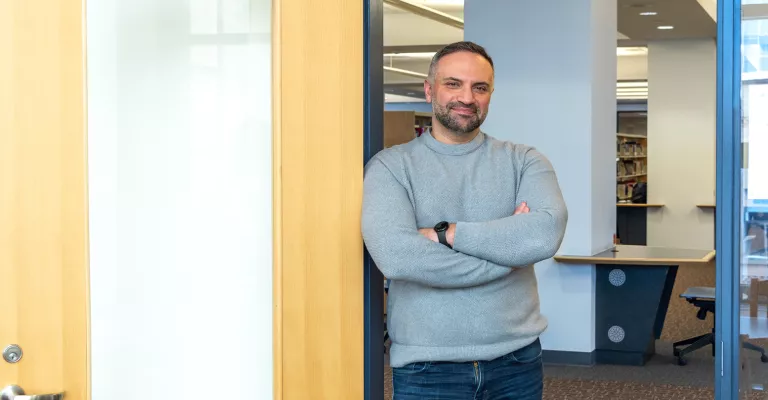 Author and Writer-in-Residence Saeed Teebi smiling and standing in the doorway of his office at Central Library
