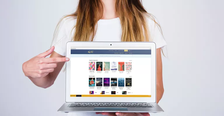 Woman pointing to laptop screen displaying updated Library catalogue