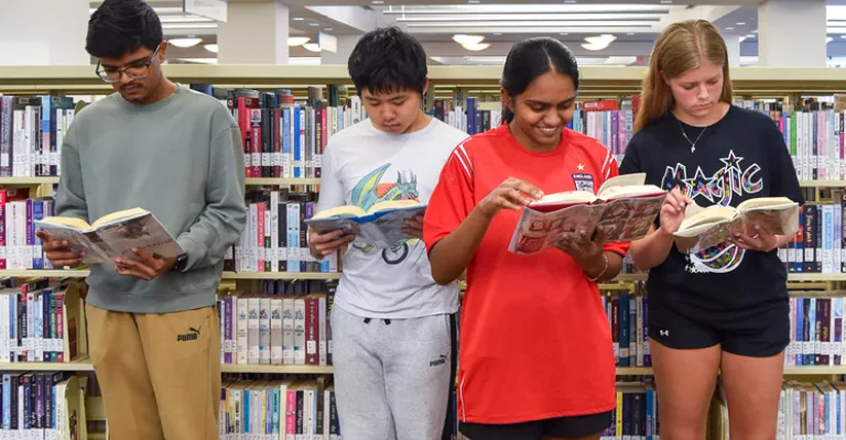 A group of teens reading in the Library