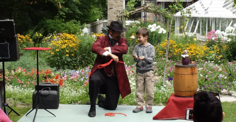 A magician performing a magic trick with a boy watching 
