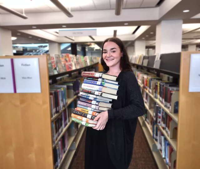 a person holding a stack of books