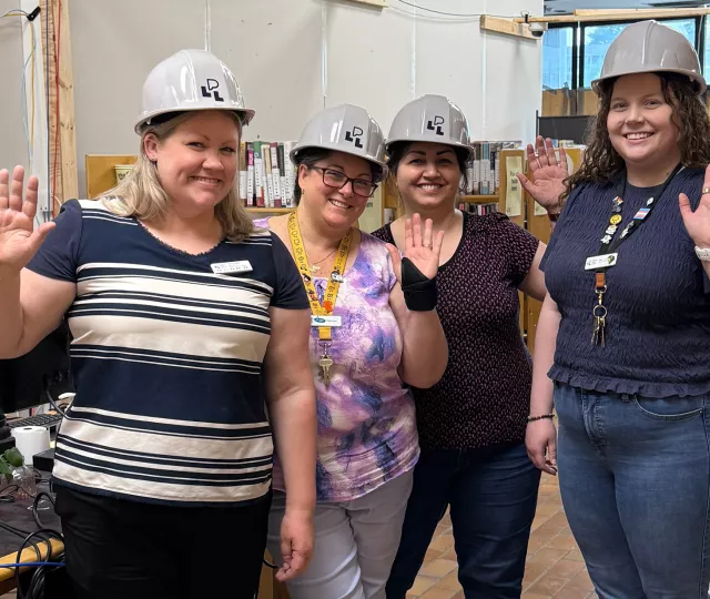 Staff stand in the Sherwood Pop-Up Library waving goodbye.