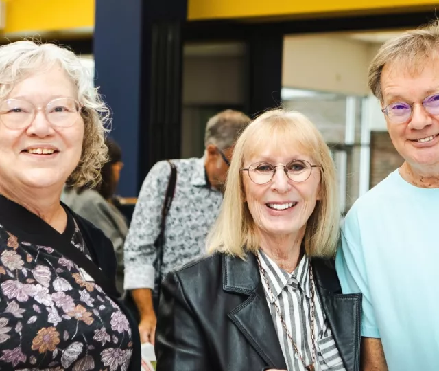 Two women and a man smile at Sherwood Branch Library.