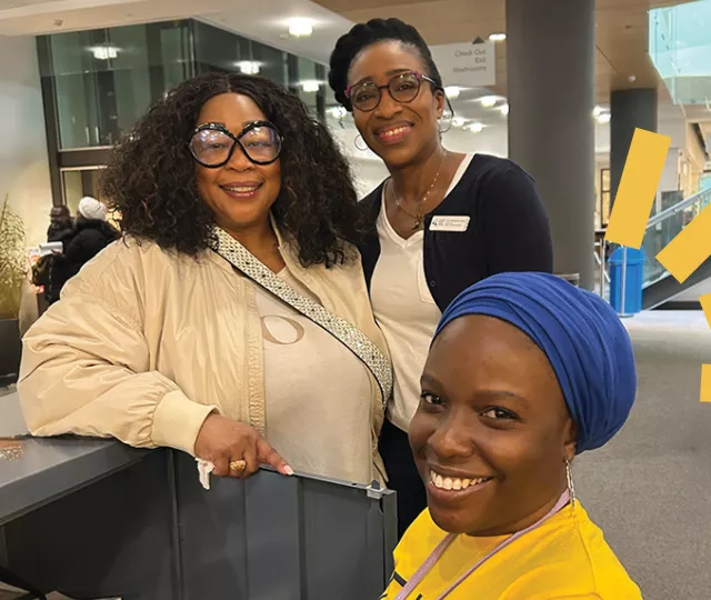 3 people stand on the main floor on central Library 