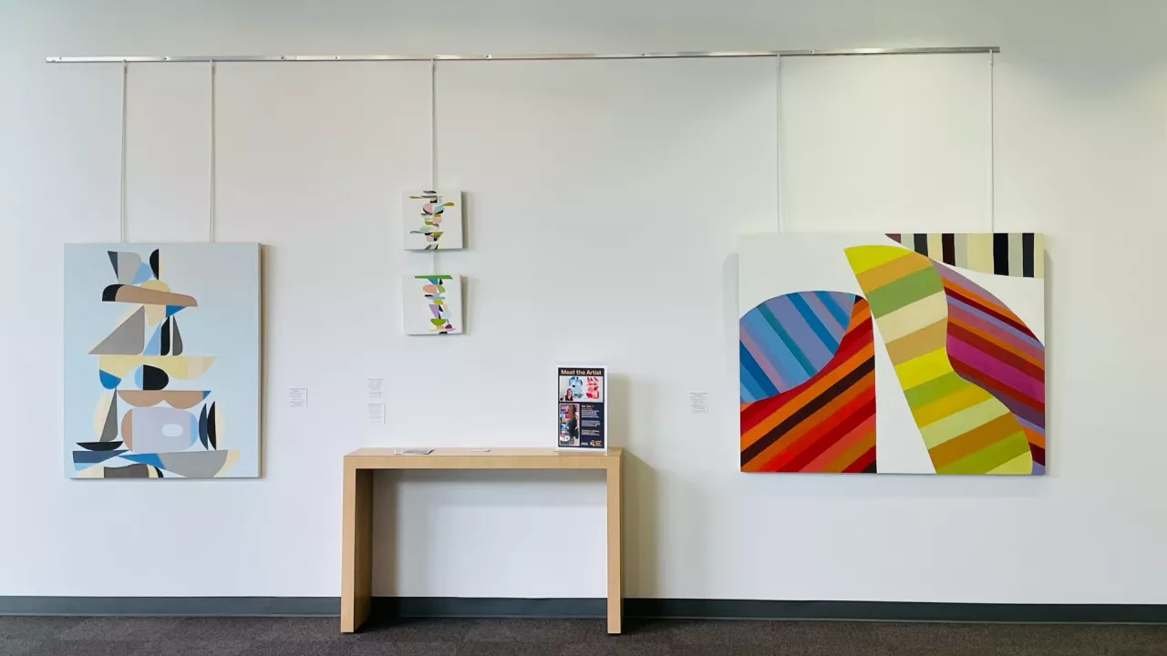 Photo of paintings by artist Deborah Worsfold hanging on a white wall at Cetnral Library.
