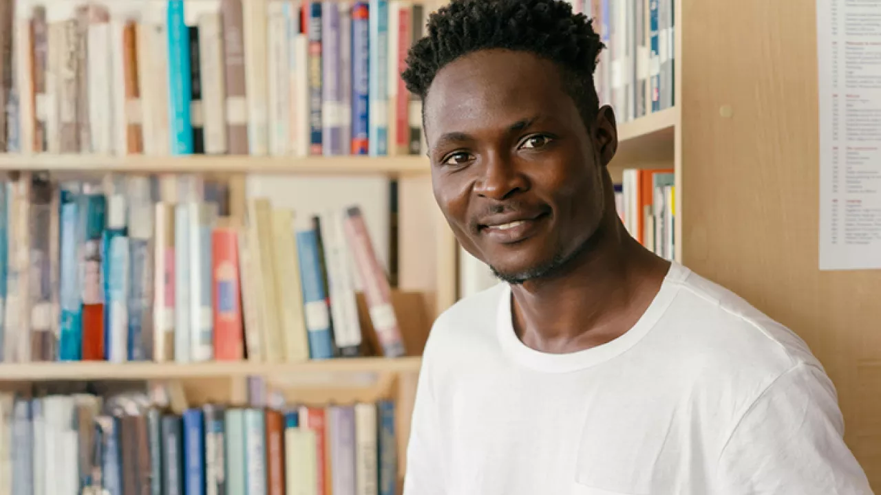 Man standing in front of Library book shelf