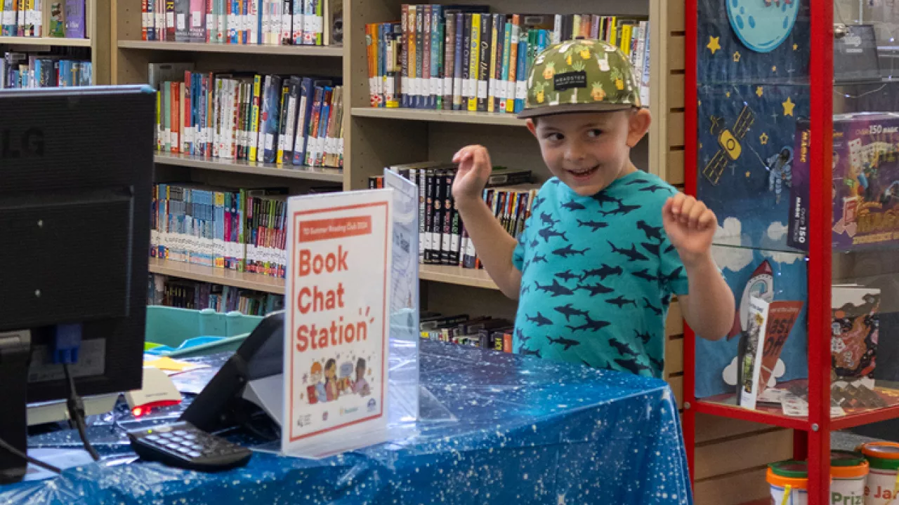 A child cheering while at the TD Summer Reading Club Book Chat Station
