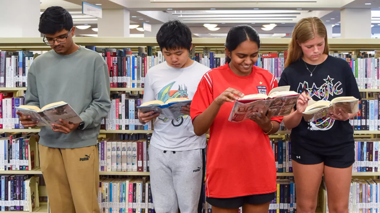 A group of teens reading in the Library