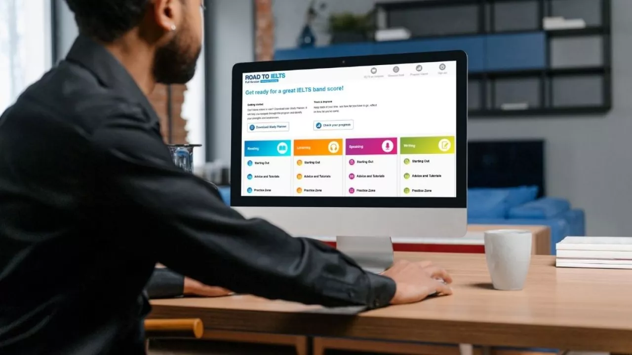 Man in front of a computer looking at list of English Language proficiency tests