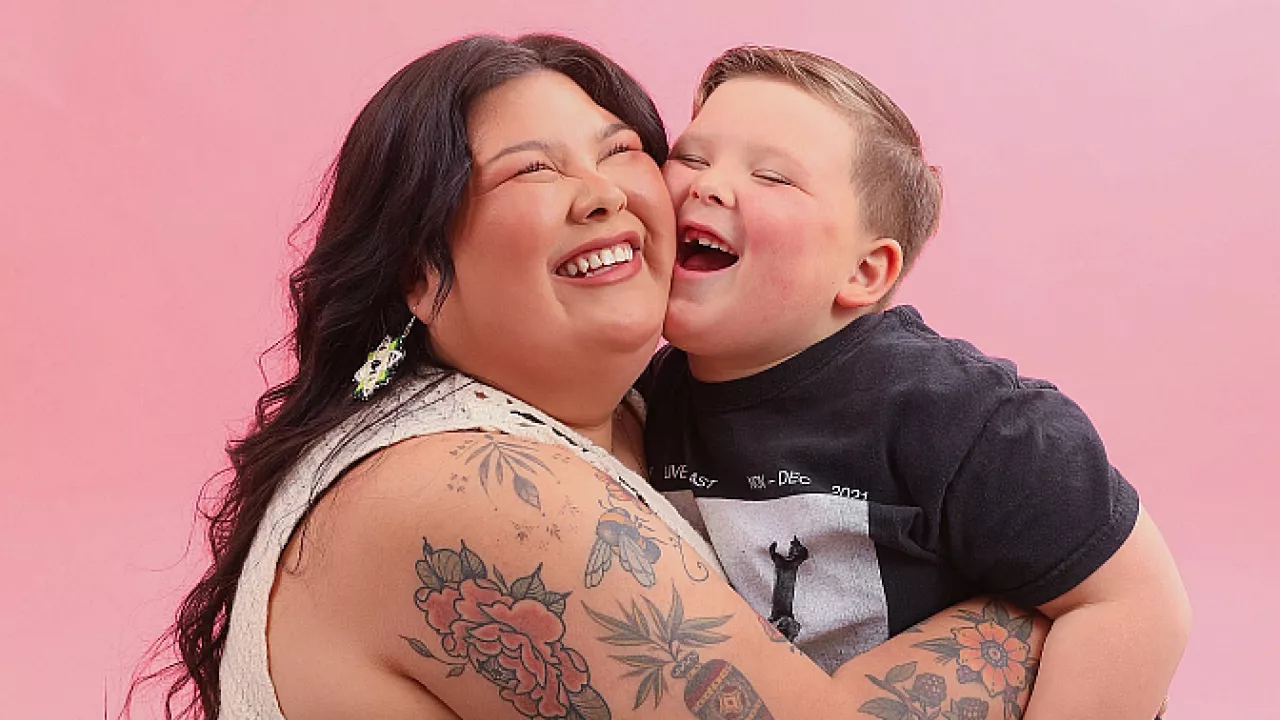 Photo of Bridget George smiling and hugging her son close.