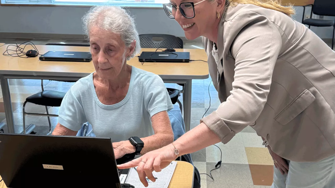 A Techknow tutor helps a senior citizen use a computer