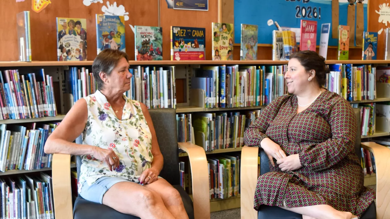 2 people chatting and sitting in chairs at the Library