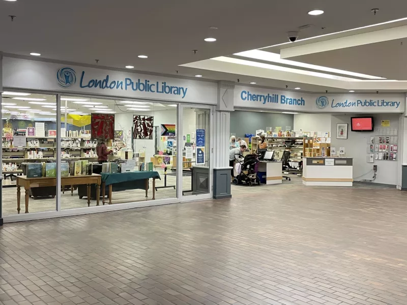 View of Cherryhill Library from inside the Mall showing bookshelves, checkout desk and displays of books.