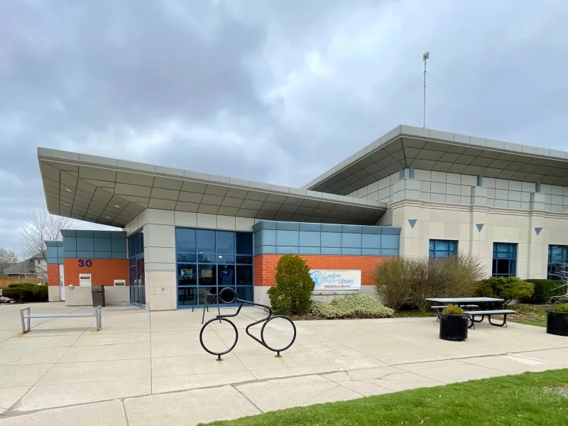 A photo of the outside of Masonville Branch Library with benches, picnic table and a bike rack in front.