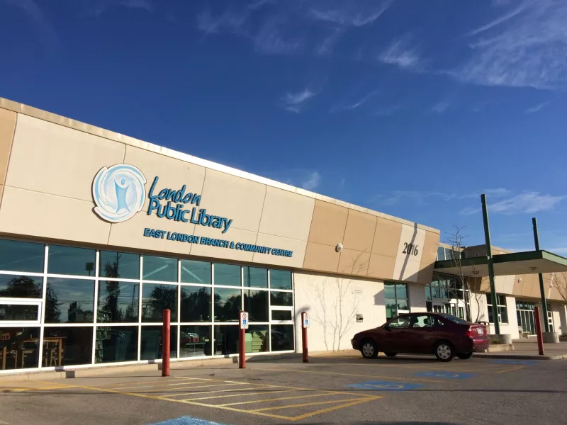 Photo of the outside of East London Branch Library with a red car in the parking lot.