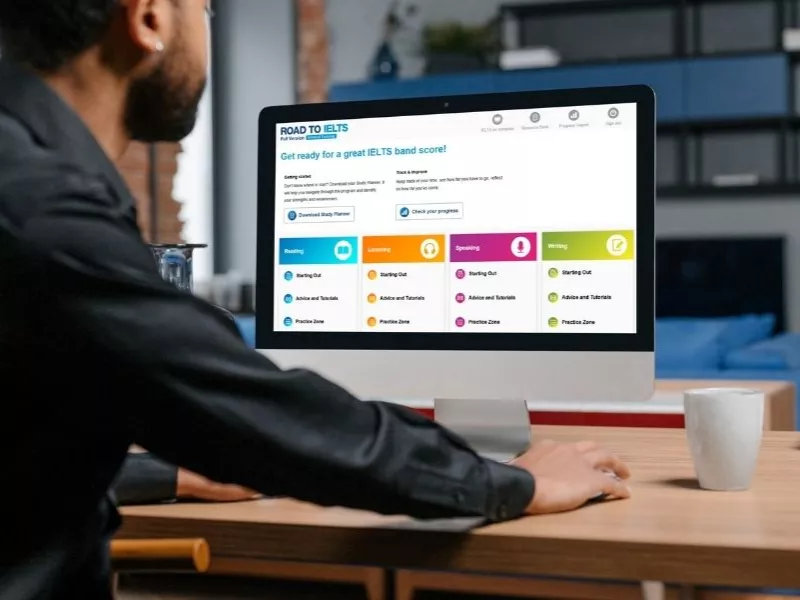 Man in front of a computer looking at list of English Language proficiency tests