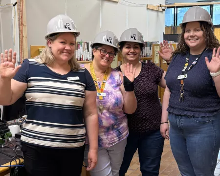 Staff stand in the Sherwood Pop-Up Library waving goodbye.