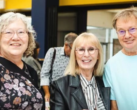 Two women and a man smile at Sherwood Branch Library.
