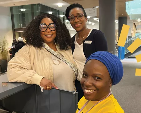 3 people stand on the main floor on central Library 