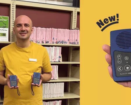 A Visiting Services Librarian holds up two new envoy players.