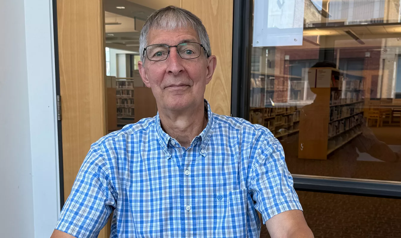 Older adult man wearing glasses in a study room