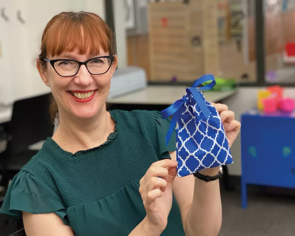 A Librarian holding a blue craft bag
