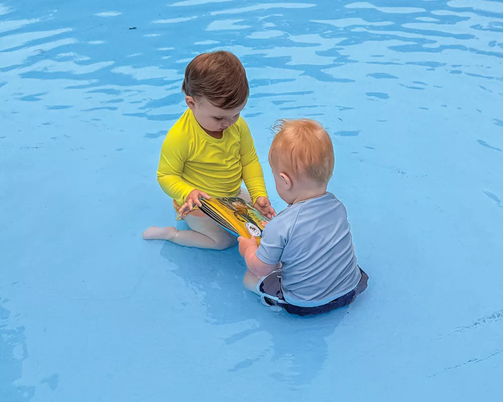 two babies playing in a pool